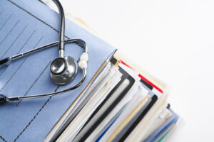 medical records stacked under a stetoschope